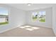 Bright bedroom featuring natural light, carpet and neighborhood view through two windows at 625 Spellbrook Rd, Zebulon, NC 27597