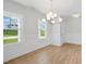 Bright dining room featuring wood floors, white wainscoting, and modern chandelier at 625 Spellbrook Rd, Zebulon, NC 27597