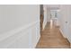 Hallway featuring beautiful wood floors, wainscoting, and staircase at 625 Spellbrook Rd, Zebulon, NC 27597