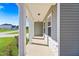 Inviting covered porch with white columns and stone accents for curb appeal at 625 Spellbrook Rd, Zebulon, NC 27597