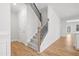 Carpeted staircase with dark metal spindles and wood railing at 625 Spellbrook Rd, Zebulon, NC 27597