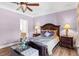 Comfortable main bedroom with a ceiling fan, lamps, and a beautiful bed at 6617 Rock Service Station Rd, Raleigh, NC 27603