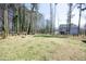 Wide backyard view with fire pit, trees, and partial view of the home's exterior at 704 Vance St, Mebane, NC 27302