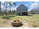 View of backyard with firepit and home with covered porch at 704 Vance St, Mebane, NC 27302