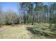Spacious backyard with a wooden fence, fire pit, stacked firewood, and plenty of green space at 704 Vance St, Mebane, NC 27302