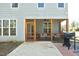 Backyard featuring a screened-in porch, grill, concrete patio, and well-maintained lawn at 704 Vance St, Mebane, NC 27302