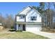 Charming two-story home featuring light blue siding, a one-car garage, and a well-manicured front yard at 704 Vance St, Mebane, NC 27302