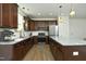 A spacious kitchen featuring dark cabinets, stainless steel appliances, and a large island with granite countertops at 704 Vance St, Mebane, NC 27302