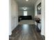 Inviting foyer with wood floors, a mirror, and a glimpse into the living room with a comfy sectional sofa at 745 Little Patch St, Zebulon, NC 27597