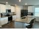 Modern kitchen boasts stainless steel appliances, a central island with seating, and white cabinetry at 745 Little Patch St, Zebulon, NC 27597