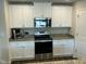 Galley kitchen showcasing modern stainless steel appliances, granite counters, and white cabinets at 745 Little Patch St, Zebulon, NC 27597