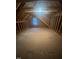 Unfinished attic space, with exposed wood beams and a small window at 945 Lynch Rd, Selma, NC 27576