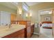 Bright bathroom with double vanities, warm wood tones, and a view into the main bedroom at 95 Blueberry Rdg, Pittsboro, NC 27312