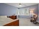 Relaxing bedroom with natural light, featuring soft blue walls, plush carpet, and a cozy rocking chair at 95 Blueberry Rdg, Pittsboro, NC 27312