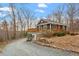Charming home exterior with a deck, gravel driveway, and natural landscaping at 95 Blueberry Rdg, Pittsboro, NC 27312