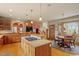 Kitchen and dining area featuring wooden floors, wooden cabinets and gas cooktop on island at 95 Blueberry Rdg, Pittsboro, NC 27312