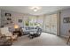 Bright living room featuring a gray sofa, comfortable chair, neutral colors, and access to an outdoor balcony at 95 Blueberry Rdg, Pittsboro, NC 27312