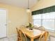 Cozy dining area featuring a classic wooden table and chairs, bathed in natural light from a bright window at 101 Tiverton Woods Dr, Holly Springs, NC 27540