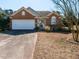 Charming single-story brick home featuring an attached garage and well-maintained front yard at 101 Tiverton Woods Dr, Holly Springs, NC 27540
