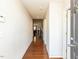 An inviting hallway featuring hardwood floors and neutral-colored walls at 101 Tiverton Woods Dr, Holly Springs, NC 27540