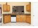 Efficient kitchen with wood cabinets, a dishwasher, and tile flooring, providing a functional space at 101 Tiverton Woods Dr, Holly Springs, NC 27540