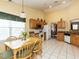 Eat-in kitchen featuring light-colored cabinets and white appliances with tile floor and a pendant light at 101 Tiverton Woods Dr, Holly Springs, NC 27540