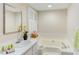 Bright bathroom featuring a soaking tub, white cabinetry, and natural light from a window at 103 Kirkwood Dr., Chapel Hill, NC 27514