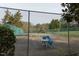 Outdoor tennis court with seating offers a recreational space with a chain-link fence, perfect for enjoying a match at 103 Kirkwood Dr., Chapel Hill, NC 27514