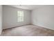 Bedroom with neutral carpeting and a window looking out to a bright green view at 103 Shelfit Trl, Oxford, NC 27565