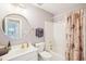 Bright bathroom with a round mirror, white vanity, and shower with floral curtain at 104 Barnes Spring Ct, Cary, NC 27519
