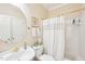 Bathroom with pedestal sink, gold hardware and lighting, and shower with curtain at 104 Barnes Spring Ct, Cary, NC 27519