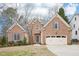 Charming brick home with a well-manicured lawn, attached garage, and inviting front entrance at 104 Barnes Spring Ct, Cary, NC 27519
