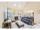 Cozy living room with a fireplace, large windows, comfortable seating, and hardwood floors at 104 Barnes Spring Ct, Cary, NC 27519