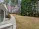 Expansive backyard featuring a lush lawn, mature trees, and a charming walkway alongside the home at 105 Aberson Ct, Cary, NC 27519
