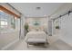 This bedroom has neutral walls, a large window, carpeted floors, decor, and a barn door for the closet at 105 Aberson Ct, Cary, NC 27519