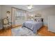 This bedroom features hardwood floors, a patterned rug, and a large window that provides natural light and an outdoor view at 105 Aberson Ct, Cary, NC 27519