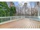 Wooden deck with white railings showcasing views of the backyard and surrounding trees at 105 Aberson Ct, Cary, NC 27519