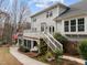 Back exterior featuring a wooden deck, screened-in porch, lush landscaping, and an American flag at 105 Aberson Ct, Cary, NC 27519