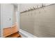 Hallway with wood floors, a decorative hook rack, and white paneled walls at 105 Aberson Ct, Cary, NC 27519