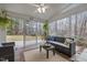 Bright sunroom with comfortable seating, ceiling fan, and serene backyard views at 105 Aberson Ct, Cary, NC 27519