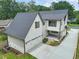 Aerial view of a white home with a gray roof, a detached garage, and a spacious driveway at 109 W Markham Ave, Durham, NC 27701