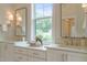 Bright bathroom featuring double sinks, framed mirrors, quartz countertops, and decorative accents at 109 W Markham Ave, Durham, NC 27701