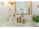 Close-up of bathroom vanity with gold fixtures, and soap with a plant adding to the decor at 109 W Markham Ave, Durham, NC 27701