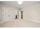 Spacious bedroom with neutral carpet, white trim, and access to a walk-in closet and bathroom at 109 W Markham Ave, Durham, NC 27701