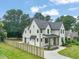 Aerial view of a white home with gray accents, a fenced yard, and a well-manicured lawn at 109 W Markham Ave, Durham, NC 27701