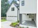 Exterior view of a home with white siding, a detached garage, and a covered patio at 109 W Markham Ave, Durham, NC 27701