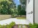Driveway leading to a detached garage with a fenced yard and lush landscaping at 109 W Markham Ave, Durham, NC 27701