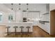 Modern white kitchen features a large island with seating, stainless steel appliances, and stylish pendant lighting at 109 W Markham Ave, Durham, NC 27701