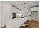 Bright kitchen boasts an island with bar stools, white cabinets, quartz countertops, and hardwood floors at 109 W Markham Ave, Durham, NC 27701