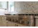 Close-up of stainless steel gas cooktop with herringbone backsplash and white cabinets at 109 W Markham Ave, Durham, NC 27701
